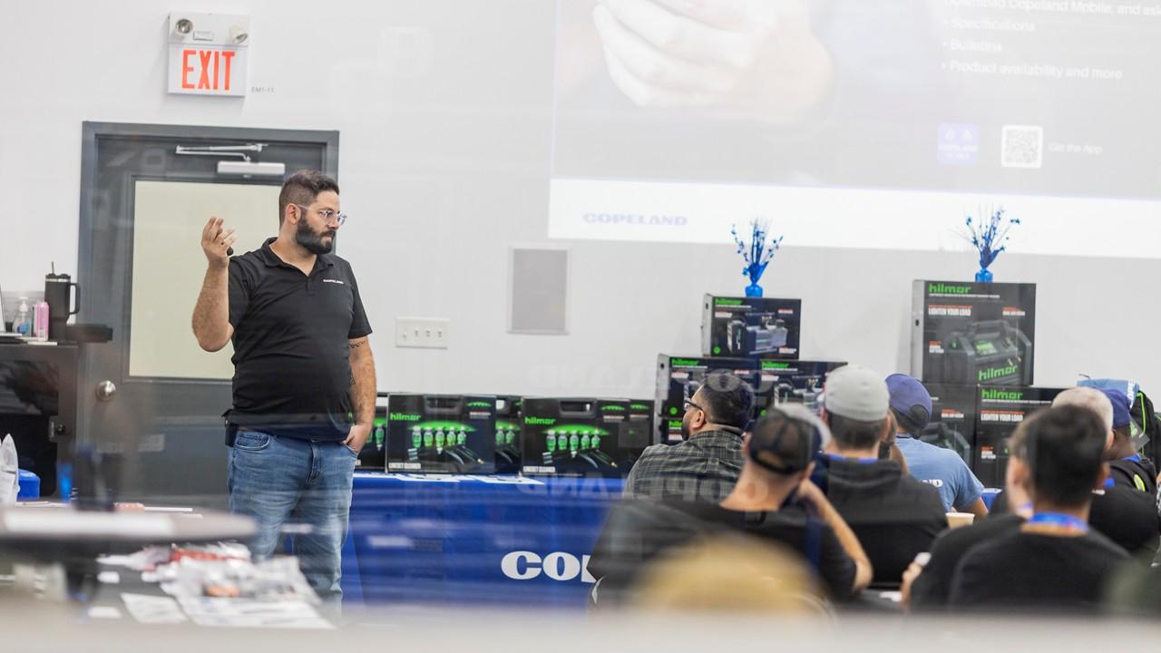 Instructor presenting auction prizes and tools to a group of HVACR apprentices