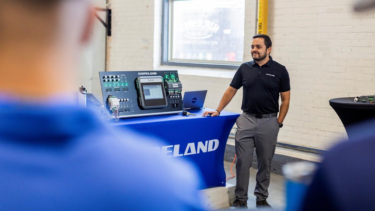 Instructor demonstrating Copeland E3 HVAC controls at the front of a classroom